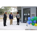 Three people talking next to an Open House sign with baloons. 