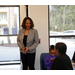 Woman standing and talking to a seated woman. 