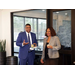 A man and a woman talking and holding refreshments. 