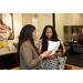 Two women talking over paperwork. 