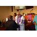 Pastor holding the hand of a congregant in the front of the church. 