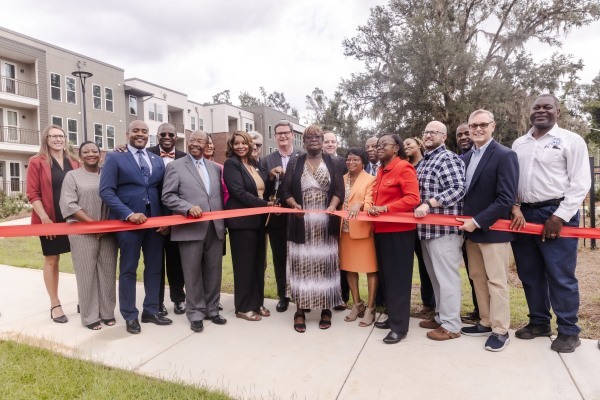 TAHAFLRibbonCuttingCover.jpg A group of people gather to cut a ribbon.